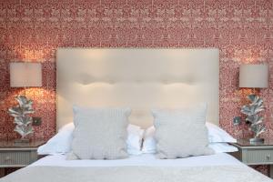 a bedroom with a white bed with two lamps at The Petersham in Richmond upon Thames
