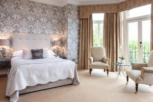 a bedroom with a bed and two chairs at The Petersham in Richmond upon Thames