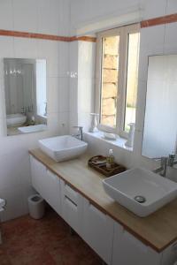 a bathroom with two sinks and two mirrors at Manoir de La Brunie-Grand Longere in Coux-et-Bigaroque