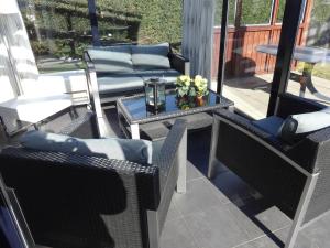 een patio met stoelen en een tafel op een balkon bij Kustverhuur, Park Scheldeveste, Schelde 220 in Breskens