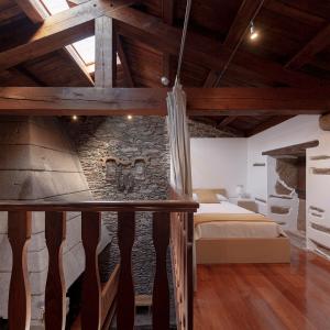 um quarto com uma cama e uma parede de pedra em A Casacuberta em Marquiño