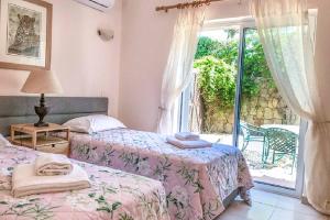 - une chambre avec 2 lits et une porte donnant sur une terrasse dans l'établissement Casa Limoeiro, à Estômbar