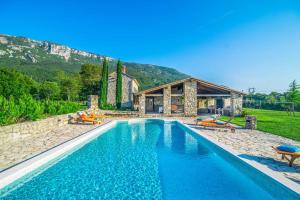 a swimming pool in front of a house at Villa Stargazer in Kozljak
