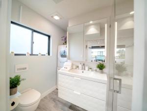 a white bathroom with a toilet and a sink at Bright European Loft In Venice Beach in Los Angeles