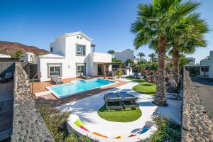 Willa z basenem i palmami w obiekcie Villa Lucero w mieście Playa Blanca