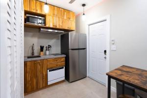 Una cocina con refrigerador de acero inoxidable y gabinetes de madera. en Elegant Miami Apartment East Little Havana / Free Parking, en Miami