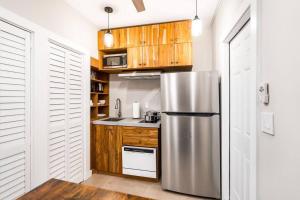 Una cocina con refrigerador de acero inoxidable y gabinetes de madera. en Elegant Miami Apartment East Little Havana / Free Parking, en Miami 15 fotos más
