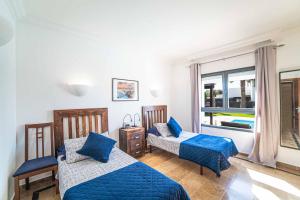 sypialnia z dwoma łóżkami i oknem w obiekcie Villa Lucero w mieście Playa Blanca