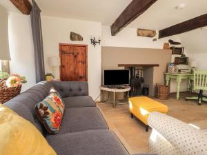 uma sala de estar com um sofá e uma televisão em Rose Cottage em Settle