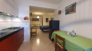 una cucina con tavolo verde e una cucina con piano cottura di Le Casette di Civitella la casa di Nonna Giulia a Civitella Del Lago