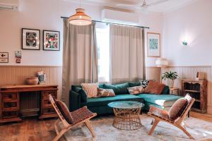 uma sala de estar com um sofá verde e cadeiras em Selina Margate em Margate