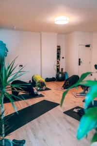 een groep mensen die yoga doen in een kamer bij Selina Margate in Margate