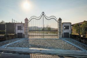 a gate in a fence with the sun behind it at Villa Agreste in Franciacorta in Passirano