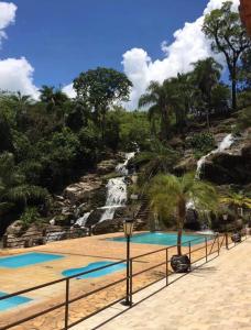 uma piscina de resort com uma cascata ao fundo em Pousada Cachoeira Dos Sonhos em Serra Negra