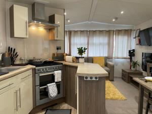 cocina con fogones y sala de estar. en VaLa VistA - Holiday Home On The Beach en Jaywick Sands