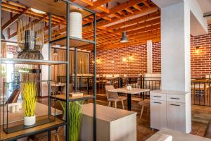 a restaurant with tables and chairs and a brick wall at Lily Beach Resort in Sozopol