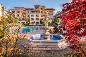 a fountain in the middle of a courtyard with a pool at Lily Beach Resort in Sozopol