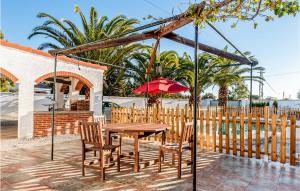 ein Tisch und Stühle und ein Sonnenschirm auf einer Terrasse in der Unterkunft Lovely Home In Chiclana De La Fronter in Chiclana de la Frontera