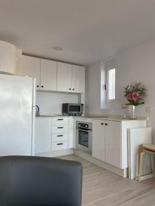 a kitchen with white cabinets and a stainless steel refrigerator at Apartamento Tres Banderas in Estepona