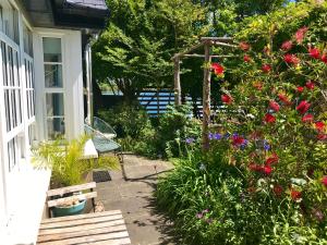 a garden with flowers and a bench next to a house at Coastal Chic waterfront studio in Kinsale