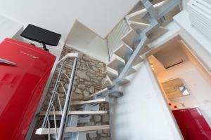 una escalera en una casa con una maleta roja en Piccola Casa Malcesine, en Malcesine