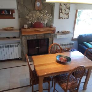 una mesa y sillas en una cocina con chimenea en Ampio Balcone SMAndes en San Martín de los Andes