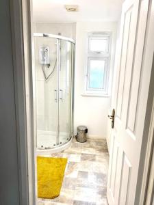 a bathroom with a shower and a yellow rug at Rochester Townhouse with parking in Strood