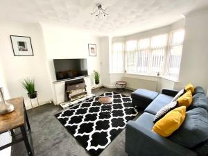 a living room with a blue couch and a black and white rug at Rochester Townhouse with parking in Strood