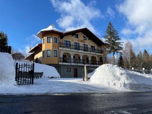 a large house with a pile of snow in front of it at Willa DINA in Wisła