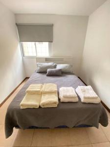 1 dormitorio con 1 cama con 3 toallas en Departamento zona Top en Godoy Cruz