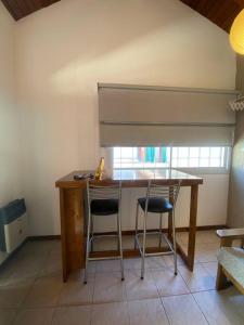 cocina con mesa de madera y 2 sillas en Departamento zona Top en Godoy Cruz