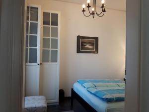 een slaapkamer met een bed en een kroonluchter bij Villa Maja in Markdorf