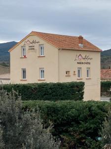 a building with writing on the side of it at L'Oustaloise in Faugères