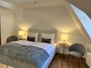 1 dormitorio con 1 cama, 1 silla y lámparas en Hotel Martin am Dom, en Bamberg