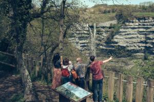 un grupo de personas de pie en una valla mirando una cascada en Moderno, céntrico. Perfecto para familias., en Vitoria-Gasteiz