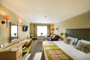a hotel room with a large bed and a living room at Leonardo Boutique Huntingtower Perth in Perth