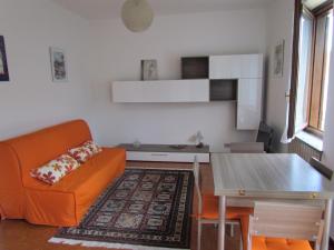 een woonkamer met een oranje bank en een tafel bij Appartamento Bilocale Dante in Stresa