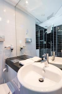 a white bathroom with a sink and a mirror at Holiday Inn Express Bremen Airport, an IHG Hotel in Bremen