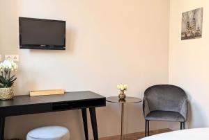 Zimmer mit einem Schreibtisch, einem Stuhl und einem TV in der Unterkunft Hotel Martin am Dom in Bamberg