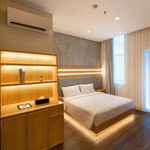 a bedroom with a bed and a desk in it at The Risman Hotel At Jakarta Airport CBC in Tangerang