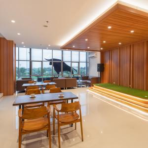 a dining room with tables and chairs and a large window at The Risman Hotel At Jakarta Airport CBC in Tangerang