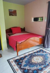 1 dormitorio con cama con sábanas rojas y alfombra en Inap Desa 3, 