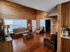 a living room with wooden walls and wooden floors at 8. Beautiful secluded creek front lodge in Guntersville