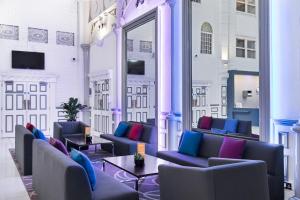 une chambre avec des canapés, des tables et une fenêtre dans l'établissement Park Inn by Radisson Cardiff City Centre, à Cardiff