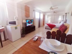 een woonkamer met een kamer met een bed en een televisie bij Toni's Cottage in Graaff-Reinet