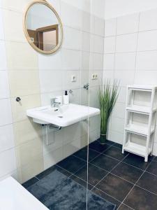 ein weißes Badezimmer mit einem Waschbecken und einem Spiegel in der Unterkunft cozy Monteurwohnung/WLAN in Bautzen