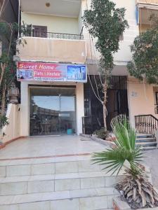 a building with a sign that reads guest home has interests at Sweet Home Hostel - ممنوع للبنات فى الوقت الحالى in Hurghada