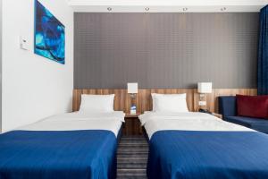a hotel room with two beds and a couch at Holiday Inn Express Bremen Airport by IHG in Bremen