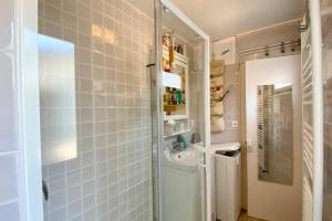een kleine badkamer met een wastafel en een douche bij Cabane du Pêcheur, maison avec extérieur in Le Crotoy