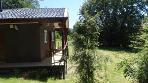 a small cabin with a deck and a tree at Parcela Parulus in Valdivia +31 photos